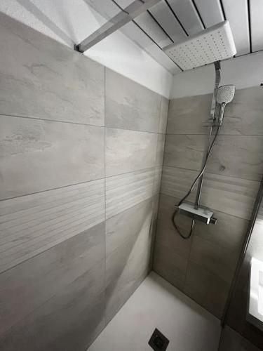 une douche avec une porte vitrée dans une salle de bain dans l'établissement Bel Appartement au coeur de la Marina Port Cogolin, à Cogolin