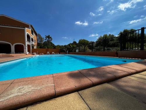 une grande piscine bleue à côté d'un immeuble dans l'établissement Bel Appartement au coeur de la Marina Port Cogolin, à Cogolin