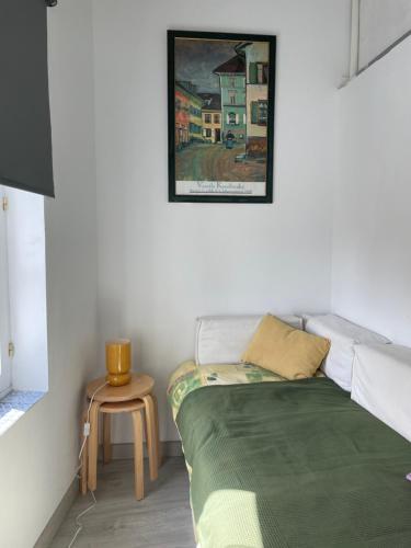 a bed in a room with a table and a picture on the wall at Luminoso Loft en la Ciudad Vieja in A Coruña