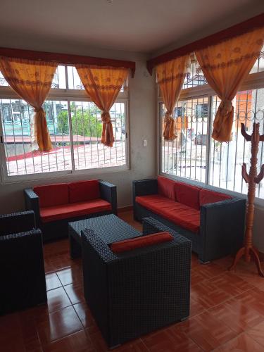 a waiting room with couches and windows at Casa Palenque in Palenque