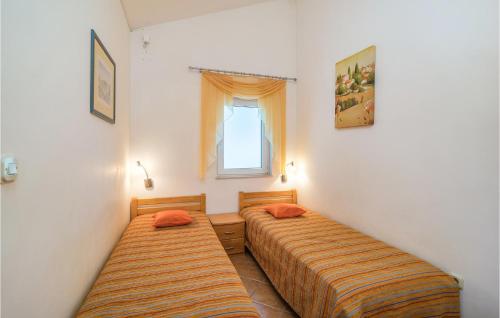 2 Betten in einem kleinen Zimmer mit Fenster in der Unterkunft 2 Bedroom Lovely Home In Vrboska in Vrboska