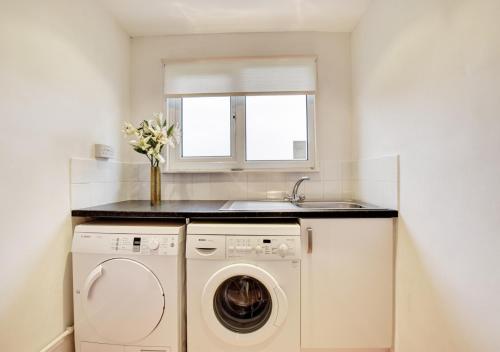 a laundry room with a washing machine and a sink at The Mount in Padstow