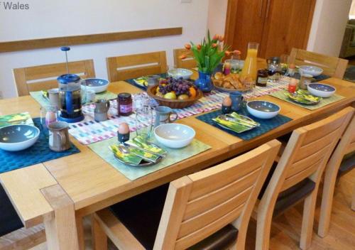 a wooden table topped with bowls and plates of food at Hafan Myrddin in Llandovery