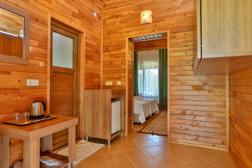 Habitación con paredes de madera y habitación con mesa. en Çıralı Orange Motel en Cıralı