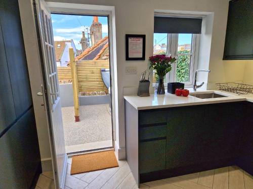 a kitchen with a counter and a view of a balcony at Wesley Chapel- Cyanacottages in Whitby