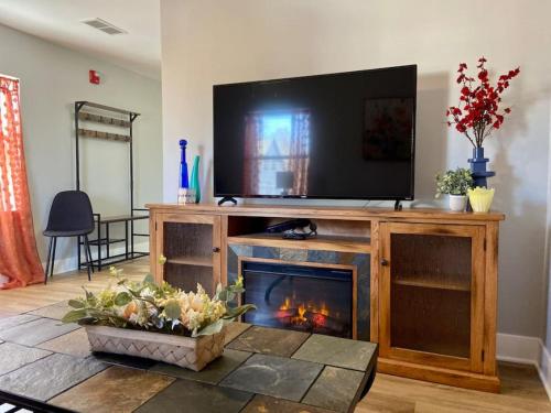 a living room with a fireplace with a television on top at SJ Suburban HiDeAwAy 