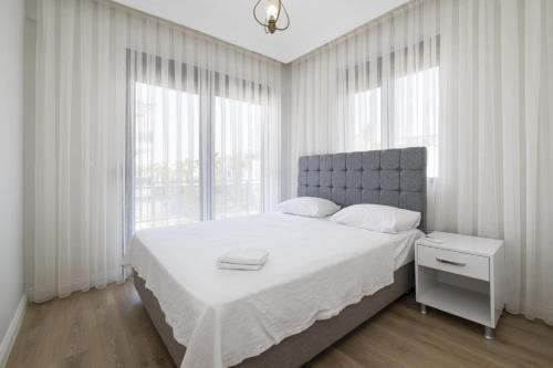 - une chambre blanche avec un grand lit et des fenêtres dans l'établissement Secluded Villa with Private Pool in Antalya, à Antalya