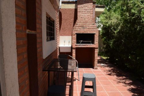 a patio with a table and a sink on a brick building at Complejo Los Cipreses in Villa Carlos Paz