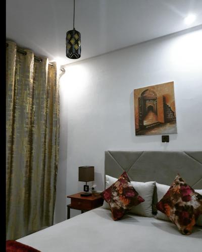 a bedroom with a bed and a lamp and curtains at White House in Azrou