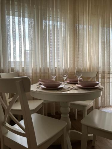 einen Tisch mit zwei Stühlen und zwei Weingläsern in der Unterkunft Warsaw Apartments Wiatraczna in Warschau
