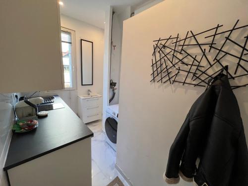 een keuken met een zwart aanrecht en een koelkast bij Cosy Studio in Bondy 15min from Paris in Bondy
