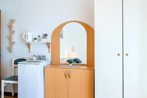 - une petite cuisine avec un évier et un miroir dans l'établissement Apartment and Rooms Dalmatiko, à Vodice