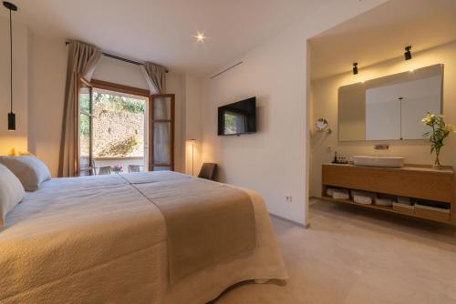 een slaapkamer met een groot bed en een wastafel bij Nema Boutique Hotel & Spa in Artá