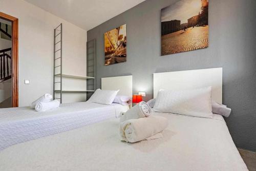 1 dormitorio con 2 camas con sábanas blancas en Aimar Atico duplex Playa la Pineda Port Aventura en La Pineda