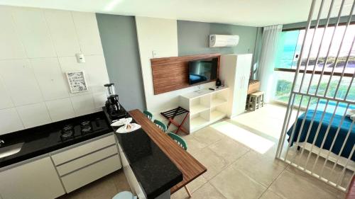 a kitchen with a stove and a tv in it at LOFT PRAIA GRANDE Vista Mar in Arraial do Cabo