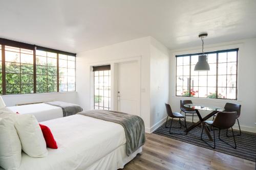 a bedroom with two beds and a table and chairs at Atterdag Inn in Solvang