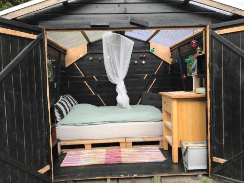 a black house with a bed and a desk at Wellness - Vildmarksbad og “shelter” in Sabro