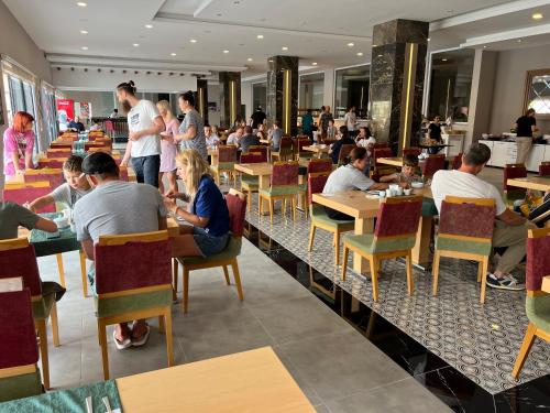 un groupe de personnes assises à table dans un restaurant dans l'établissement ArdorMare Hotel, à Alanya