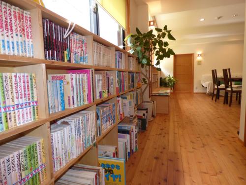 a row of library shelves filled with books at Guesthouse Hyakumanben Cross in Kyoto