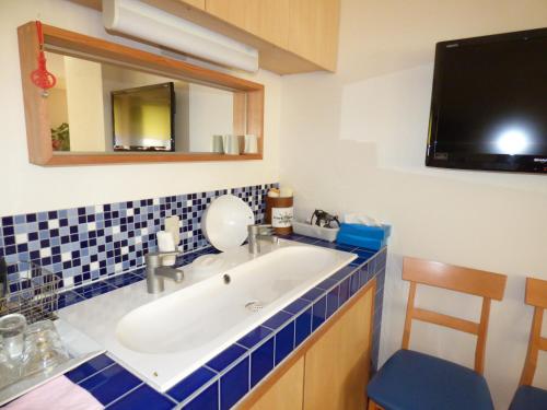 a bathroom with a sink and a mirror at Guesthouse Hyakumanben Cross in Kyoto