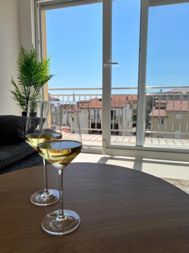 a glass of wine sitting on a table in front of a window at Apartment Los Anđeles in Podstrana