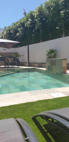 une piscine avec de l'eau bleue dans une cour dans l'établissement la maison d'amiata avec piscine, à Agde