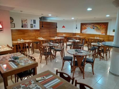 ein Esszimmer mit Tischen und Stühlen in einem Restaurant in der Unterkunft ROMA'S HOTEL in Umuarama