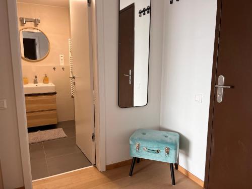 a bathroom with a blue stool in front of a door at SKAU Blue Residence in Sky Park 21 floor 2 tower Panoramic View Free Parking in Bratislava