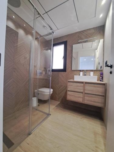 a bathroom with a toilet and a sink and a mirror at Luxury Apartment La Mata right by the sea in La Mata