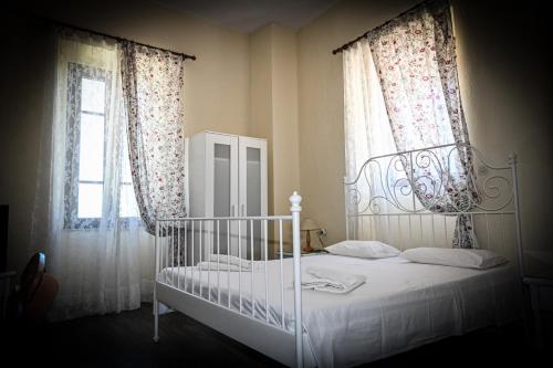 a bedroom with a white bed and two windows at Nymph in Sálakos