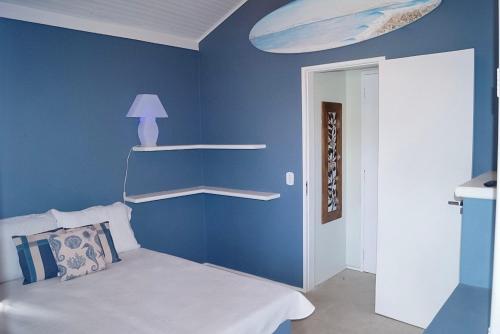 Dormitorio azul con cama y pared azul en Linda casa em Geribá, en Búzios