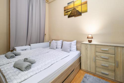 ブダペストにあるTravelers Apartmentのベッドルーム(大きな白いベッド1台、ドレッサー付)