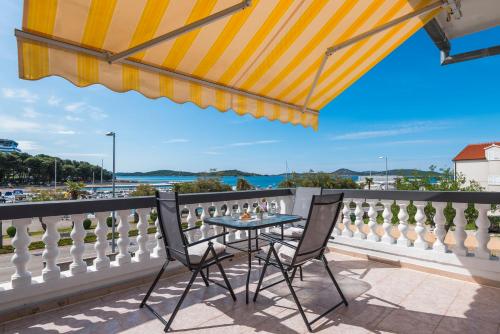 a patio with a table and chairs on a balcony at Apartment and Rooms Dalmatiko in Vodice