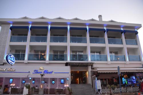 a large white building with blue lights on it at Devamli Hotel in Marmaris