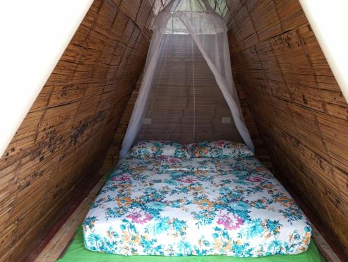 uma cama num pequeno quarto com uma janela em tukamping em Minca