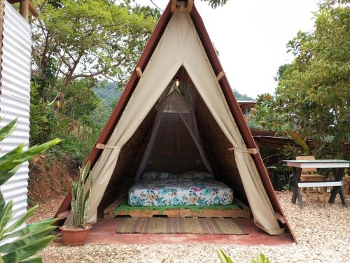 - un lit dans une tente en tipi dans un jardin dans l'établissement tukamping, à Minca