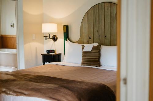 - une chambre avec un grand lit et une tête de lit en bois dans l'établissement Volcano Union Inn and Pub, à Volcano