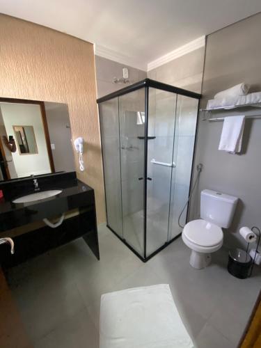 ein Bad mit einer Dusche, einem WC und einem Waschbecken in der Unterkunft VIPPER Hotel in Aparecida