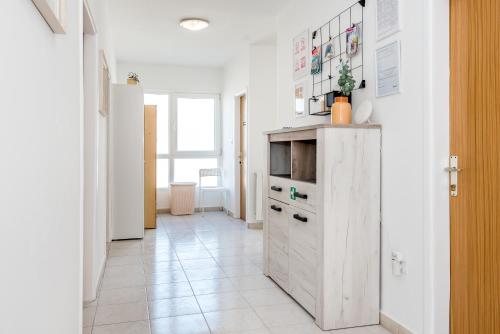 a kitchen with a white cabinet and a tile floor at Apartment and Rooms Dalmatiko in Vodice
