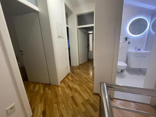 Un baño blanco con inodoro y lavabo. en Villa Tamara with garden and river view - free private parking & garage, en Mostar