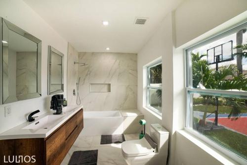 a bathroom with a white tub and a sink and a window at Entertainment Elegance - Miami Villa L33 in Tamiami