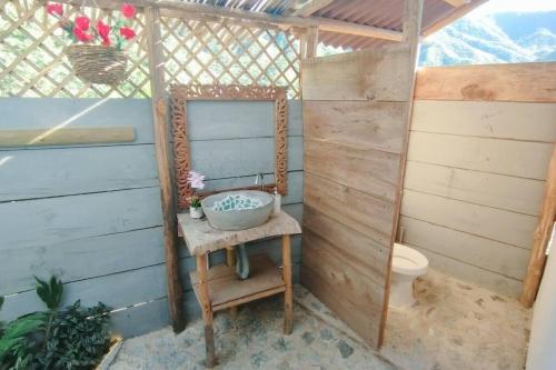 e bagno con servizi igienici e specchio su sedia. di GLAMPING BAReKE AZUL2 a Santa Marta