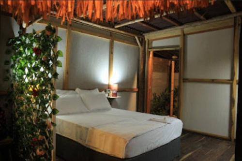 Dormitorio con cama y árbol de Navidad en GLAMPING BAReKE AZUL2, en Santa Marta