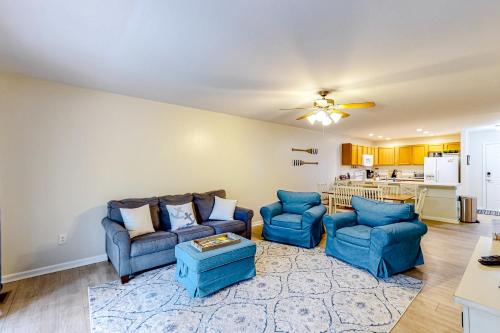 a living room with two blue couches and a kitchen at Lake Bliss in Mineral