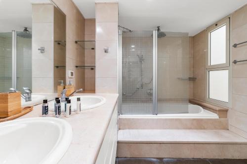 uma casa de banho com 2 lavatórios e um chuveiro em The gaudi house TLV em Tel Aviv