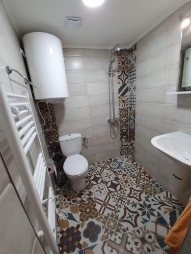 a bathroom with a toilet and a sink at Стаи за гости Елеганс in Elena