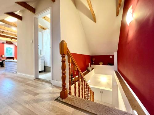 a staircase in a house with a red wall at White House Zalakaros in Zalakaros