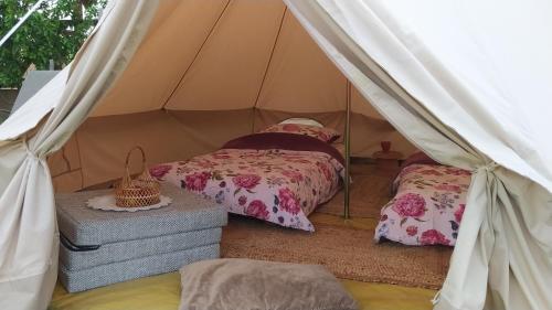 a bedroom with two beds in a canvas tent at Domek na wsi 