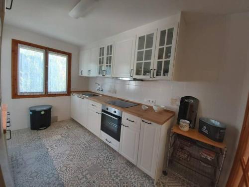 a kitchen with white cabinets and a stove top oven at Villapolonia, casa 8 pax. piscina y aire ac. in Benicàssim