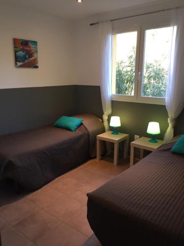 - une chambre avec 2 lits et 2 lampes sur les tables dans l'établissement Chez Pierre à Porto-Vecchio, à Porto-Vecchio